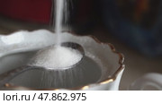White sugar pouring into elegant tea cup with spoon. Стоковое видео, видеограф Андрей Знаменский / Фотобанк Лори