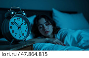 Restless thoughts a contemplative woman in bed under soft blue tones with an alarm clock capturing the essence of insomnia and pensive emotion. Стоковое AI-изображение, AI-художник Андрей Бакусов / Фотобанк Лори