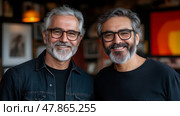 Two men pose for a picture, both sporting grey beards and glasses. They smile warmly, showcasing a relaxed atmosphere filled with art. Стоковое AI-изображение, AI-художник Данила Большаков / Фотобанк Лори