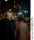 A couple walks hand in hand along a red carpet, illuminated by dazzling city lights in the evening, sharing smiles and lighthearted conversation. Стоковое AI-изображение, AI-художник Данила Большаков / Фотобанк Лори