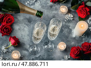 Champagne, candles and red roses. Gray concrete background. Above view. Valentines drinks for for a pair of lovers. Bartender pours sparkling wine or prosecco into glasses. Romance. Wedding Day. Стоковое AI-изображение, AI-художник Марина Демидюк / Фотобанк Лори