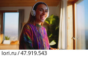 A woman is smiling and wearing headphones while looking out the window. Стоковое AI-видео, аниматор Виктория Кольцова / Фотобанк Лори
