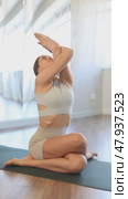 Calm european young female gym trainer practicing advanced yoga, variations of half lord pose or Ardha Matsyendrasana during yoga training in yoga studio. Стоковое видео, видеограф Яков Филимонов / Фотобанк Лори