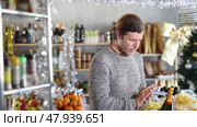 Portrait of man with cart shopping at supermarket, looking for something to buy. Christmas shopping. Стоковое видео, видеограф Яков Филимонов / Фотобанк Лори