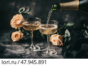Champagne and red pink roses on a black concrete background. Copy space for text. Valentines drinks for for a pair of lovers. Bartender pours prosecco sparkling wine into glasses. Romance. Wedding Day. Стоковое AI-изображение, AI-художник Марина Демидюк / Фотобанк Лори