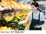 Female employee informs about arrival of ripe zucchini, advertises product. Стоковое фото, фотограф Яков Филимонов / Фотобанк Лори