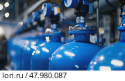 Close-up of blue industrial oxygen tanks arranged in a line within a production facility. Стоковое AI-видео, аниматор Михаил Строгалев / Фотобанк Лори