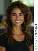 Young woman with curly hair and a warm smile poses in a well-lit indoor space, exuding confidence and approachability during midday. Стоковое AI-изображение, AI-художник Данила Большаков / Фотобанк Лори