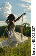 A dancer expresses freedom and joy while twirling in a sunlit grassy field. Стоковое AI-изображение, AI-художник Данила Большаков / Фотобанк Лори