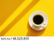 Утренняя чашка чёрного кофе на солнце. Стоковое AI-изображение, AI-художник Александр Жуков / Фотобанк Лори