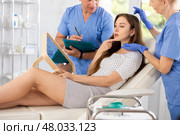 Plastic surgeon and nurse consulting young woman before facelift operation in clinic. Стоковое фото, фотограф Яков Филимонов / Фотобанк Лори