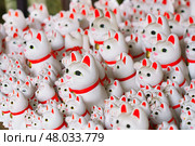 Tokyo, Japan - Sep 30 2024, A close-up view of many multi-sized white beckoning cat figure of Maneki neko with red ears and noses displayed at Gotokuji Temple, without people, at daytime, Tokyo, Japan. Стоковое фото, фотограф Сергей Богомяко / Фотобанк Лори