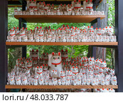 Tokyo, Japan - Sep 30 2024, A close-up view of many multi-sized white beckoning cat figure of Maneki neko with red ears and noses displayed at Gotokuji Temple, without people, at daytime, Tokyo, Japan. Стоковое фото, фотограф Сергей Богомяко / Фотобанк Лори