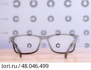 Glasses for vision are on the table, next to Golovin table, for checking visual acuity and diseases of the eye. Стоковое фото, фотограф Скрипачев Антон / Фотобанк Лори