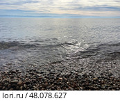 Tranquil autumn scene at lake baikal with pebbled shoreline under cloudy sky. Стоковое фото, фотограф Бакина Александра / Фотобанк Лори