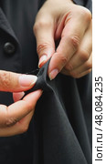 A close-up of a woman's hands sewing a black cloth banner, her fingers trembling slightly as she prepares for the Ashura process. Стоковое AI-видео, аниматор Sergey Grishin / Фотобанк Лори