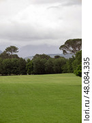 Natural landscape, hotel golf club territory. An ideal field, sown with lawn grass, surrounded by deciduous trees. Стоковое фото, фотограф Екатерина Якименко / Фотобанк Лори