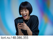 Young Asian Woman with Sleek Bob Scrolling Smartphone with excitement. Молодая женщина азиатского происхождения с гладкой черной стрижкой боб, с увлечением читает на своем смартфоне, на фоне яркого цифрового фона. Стоковое AI-изображение, AI-художник Katsiaryna Repich / Фотобанк Лори