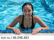 Beautiful, cheerful young woman leaned her hands on the edge of the pool. Стоковое AI-изображение, AI-художник Дмитрий Киселёв / Фотобанк Лори