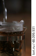 Brewing Tea A CloseUp View of the Infuser and Fresh Tea Leaves Unveiled for All. Стоковое фото, фотограф David Kashakhi / Фотобанк Лори
