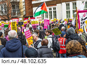 Crowded public demonstration with protesters holding signs and flags. London, UK, 16 March 2024. Редакционное фото, фотограф Zydrius Tartenis / Фотобанк Лори