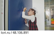 1 september 2022, Kazan, Russia - Schoolgirl writing numbers on blue wall in corridor. Редакционное видео, видеограф Константин Шишкин / Фотобанк Лори