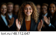 A woman with curly hair smiles confidently while receiving applause from a group of well-dressed professionals in a corporate gathering. Стоковое AI-изображение, AI-художник Данила Большаков / Фотобанк Лори