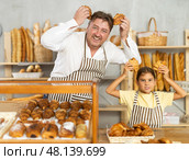 Uncle and girl are laughing, having fun, doing prank in trading floor of bakery store. Стоковое фото, фотограф Татьяна Яцевич / Фотобанк Лори