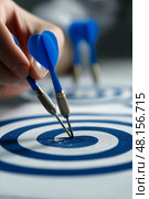 Dart Player Retrieves Darts From Blue and White Target During Competitive Match. Стоковое AI-изображение, AI-художник Юлия Гапеенко / Фотобанк Лори
