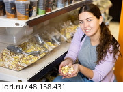Woman holding handful of dry food for dog in pet store. Стоковое фото, фотограф Яков Филимонов / Фотобанк Лори