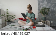 Remote designer brainstorming new project ideas, sketching concepts on digital tablet. Home workspace creates an inspiring atmosphere for productivity and creativity. Freelance and remote work themes. Стоковое видео, видеограф Енваев Андрей / Фотобанк Лори
