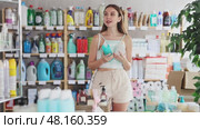 Woman looking for trademark sign on label, chooses eco friendly shampoo or shower gel. Стоковое видео, видеограф Яков Филимонов / Фотобанк Лори