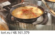 Meat and seafood paella cooked in frying pan. Стоковое видео, видеограф Яков Филимонов / Фотобанк Лори