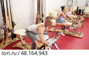 Young man stretching his arms using pilates machine. Стоковое видео, видеограф Яков Филимонов / Фотобанк Лори