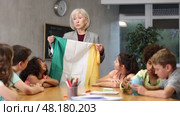 in entertaining geography lesson, children look at flag of Ireland with interest. Стоковое видео, видеограф Яков Филимонов / Фотобанк Лори