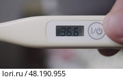 Home electronic thermometer indicates a temperature of 36.6 degrees Celsius. Стоковое видео, видеограф Strunov David / Фотобанк Лори