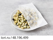 Drying of diced eggplants with a paper towel on a gray textured background. Processing eggplant before cooking, removing bitterness. Стоковое фото, фотограф Ольга Лепёшкина / Фотобанк Лори