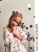 A 6-year-old girl model creatively poses in a studio, showcasing her playful personality. Стоковое фото, фотограф Aleksandr Golubev / Фотобанк Лори