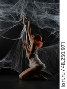 Red-haired woman entangled in a net trap resembling a spider web. Стоковое фото, фотограф Гурьянов Андрей / Фотобанк Лори