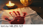 A close-up of a bloodied handprint on a white cloth, symbolizing sacrifice, illuminated by the dim glow of a single oil lamp. Стоковое AI-видео, аниматор Sergey Grishin / Фотобанк Лори
