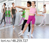 Teenage girl practicing ballet positions in pair with boy in dance studio. Стоковое фото, фотограф Яков Филимонов / Фотобанк Лори