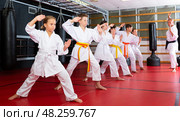 Children wearing karate uniform practicing new moves in group. Стоковое фото, фотограф Яков Филимонов / Фотобанк Лори