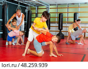 Boys and girls in gym exercising armlock move. Стоковое фото, фотограф Яков Филимонов / Фотобанк Лори