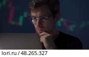 Trader with glasses monitors the financial market on his computer. Стоковое видео, видеограф Arsenii Palivoda / Фотобанк Лори