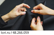A close-up of a woman's hands sewing a black cloth banner, her fingers trembling slightly as she prepares for the Ashura process. Стоковое AI-видео, аниматор Sergey Grishin / Фотобанк Лори