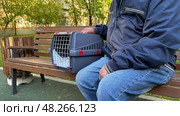 An elderly man holds a cat in a carrier. Pet transportation, traveling with a pet. A close friend of an elderly man. Стоковое фото, фотограф Терехова Марина / Фотобанк Лори