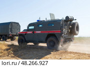 Бронированный автомобиль ГАЗ Тигр военной полиции движется по полевой дороге. Средняя Ахтуба, Волгоградская область, Россия (2021 год). Редакционное фото, фотограф Андрей Цыганков / Фотобанк Лори