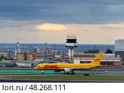 LISBON, PORTUGAL - MAY 1, 2025: DHL Aviation Airplane Taxiing at the Airport. Редакционное фото, фотограф Максим Забаровский / Фотобанк Лори