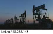 Many working oil pumps silhouette in dusk, 4k. Стоковое видео, видеограф Михаил Коханчиков / Фотобанк Лори