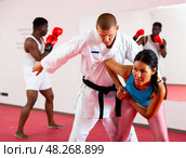 Woman is practicing self-defence fight in pair with trainer in gym. Стоковое фото, фотограф Яков Филимонов / Фотобанк Лори